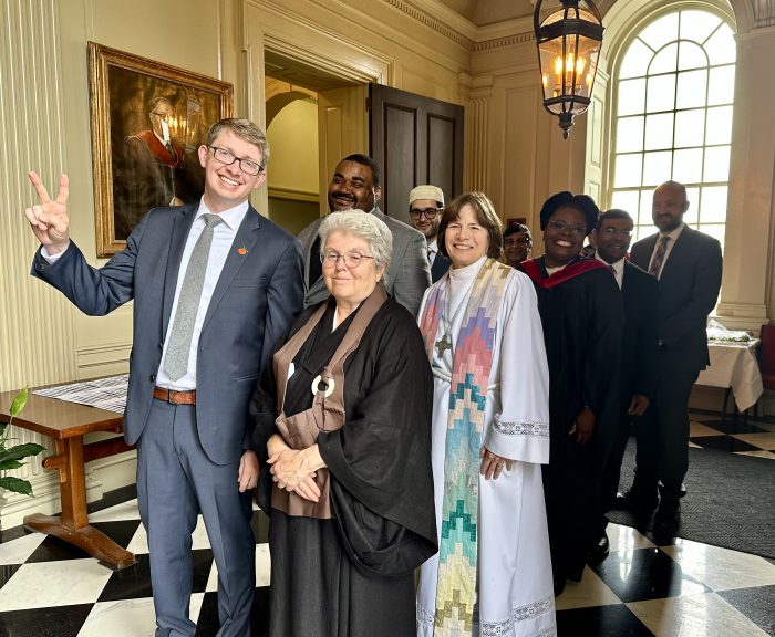 Lutheran pastor Rev. Gail Riina stands with fellow chaplains in her white pastor's robe.